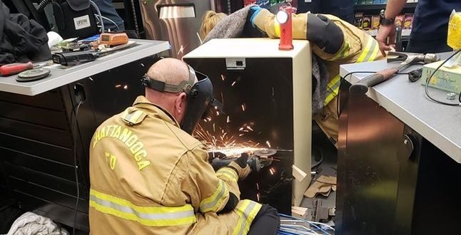 Firefighters disassemble safe to free woman after three long hours.